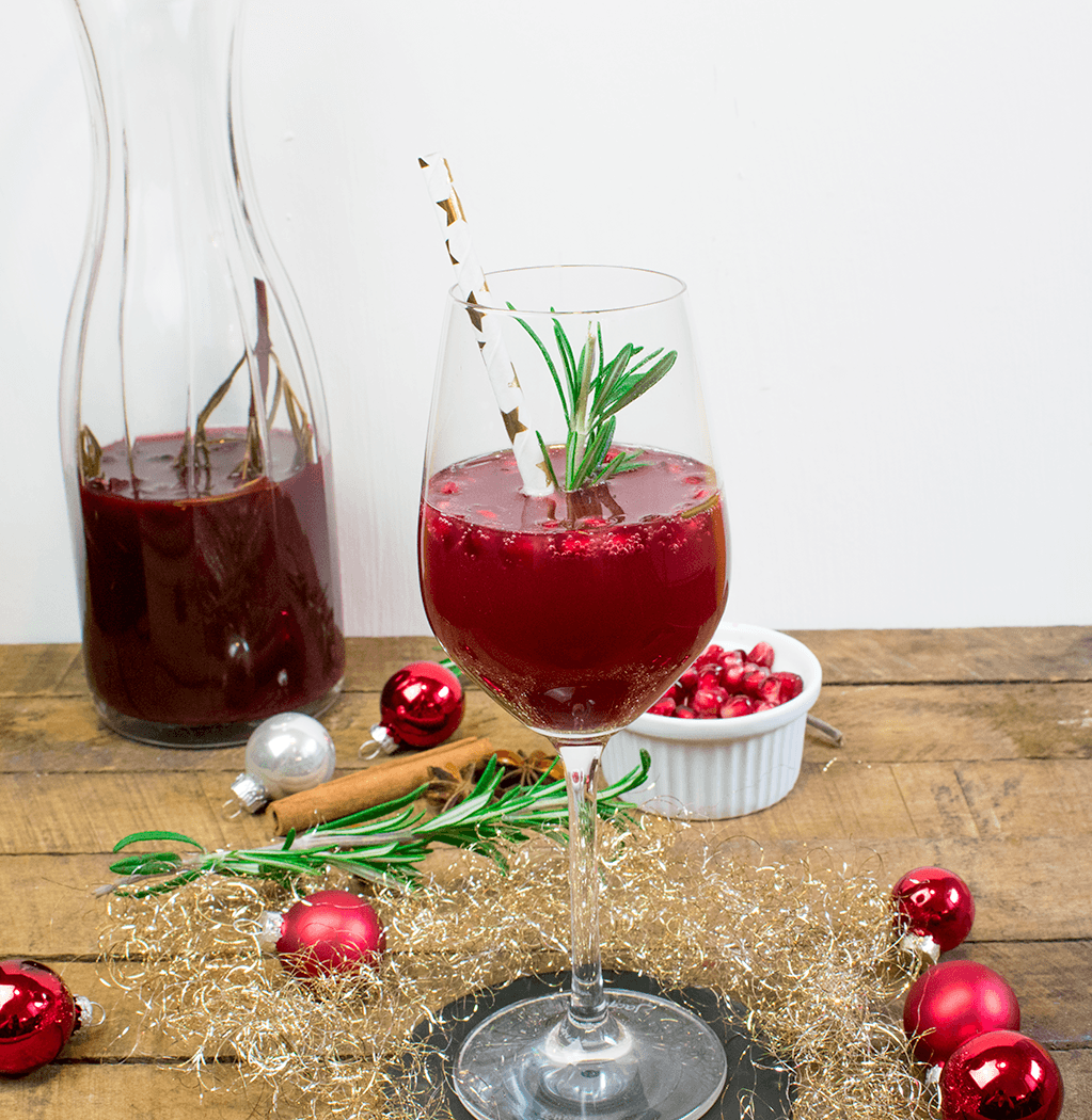 Champagnercocktail mit Zimt, Sternanis, Cranberries und Rosmarin