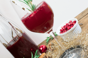 Champagnercocktail mit Zimt, Sternanis, Cranberries und Rosmarin