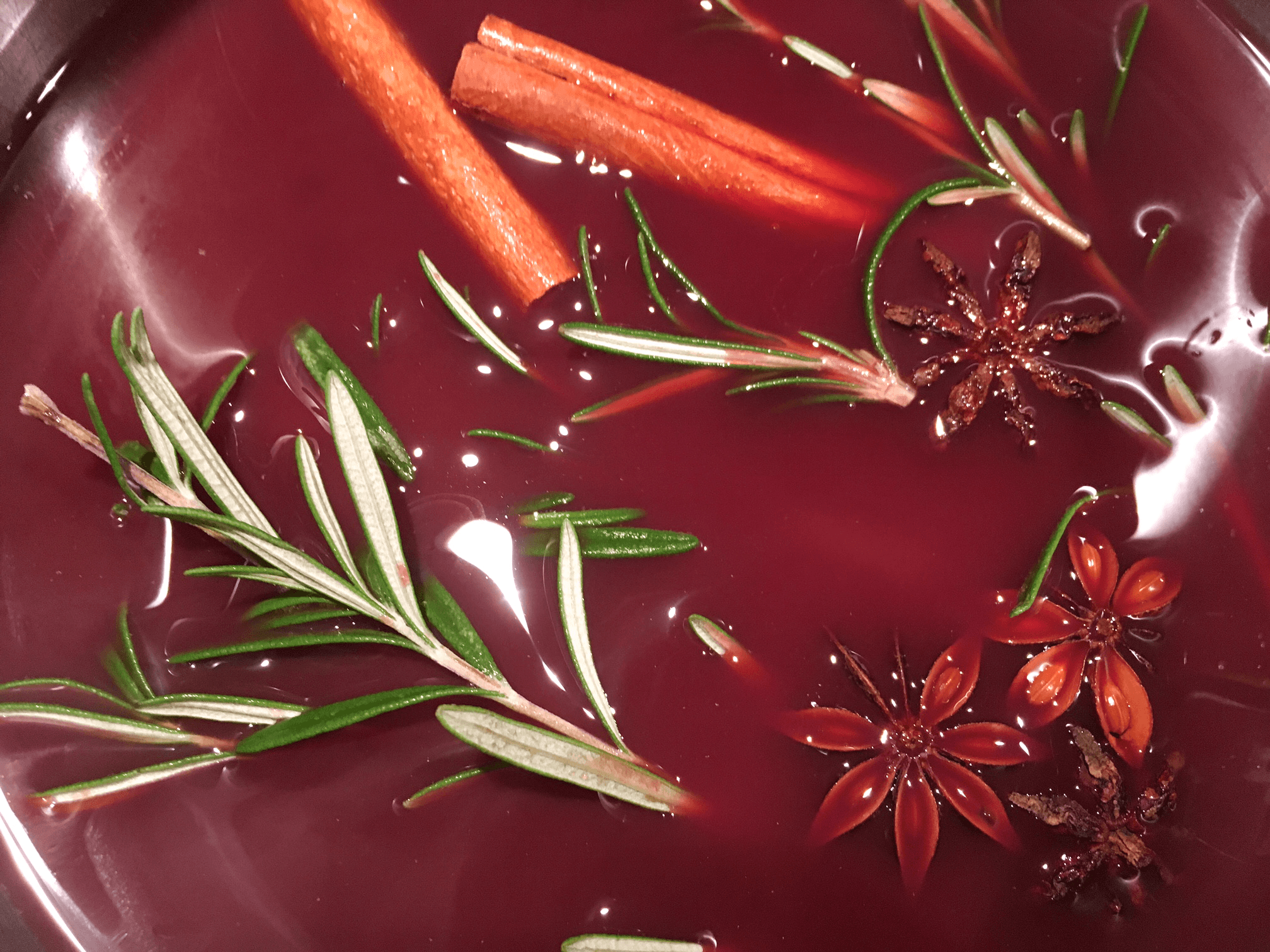 Champagnercocktail mit Zimt, Sternanis, Cranberries und Rosmarin