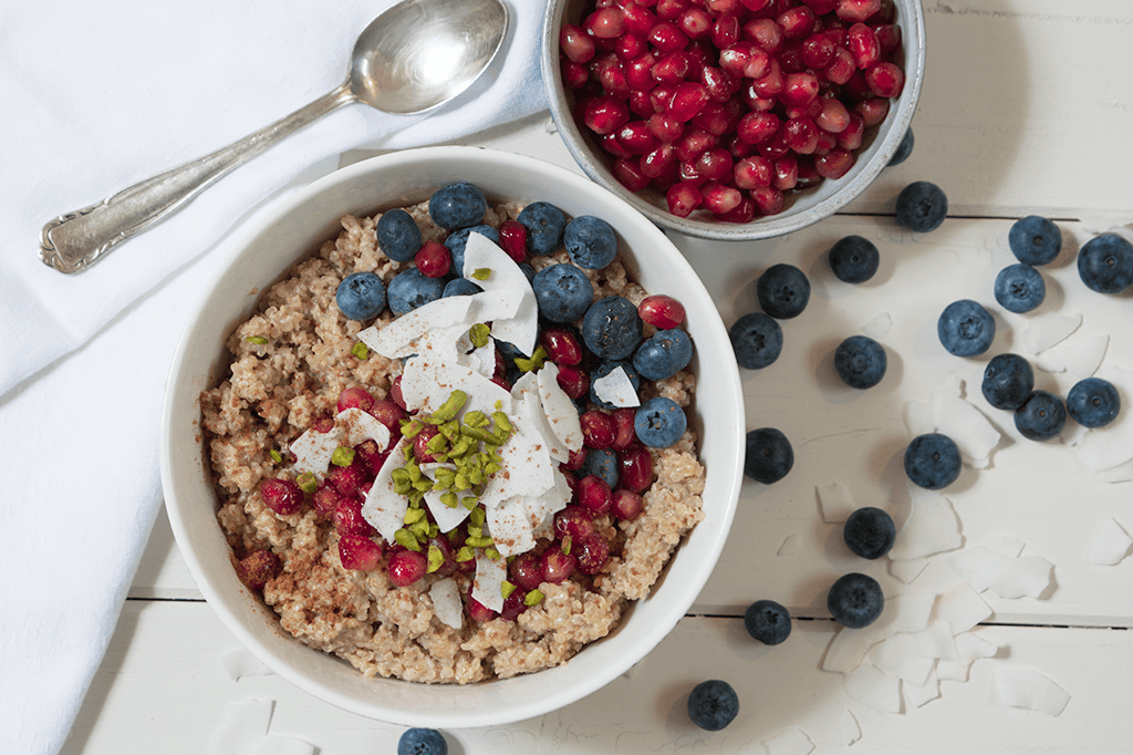 Quinoa-Porridge mit Blaubeeren, Granatapfel, Kokosflocken und Pistazien