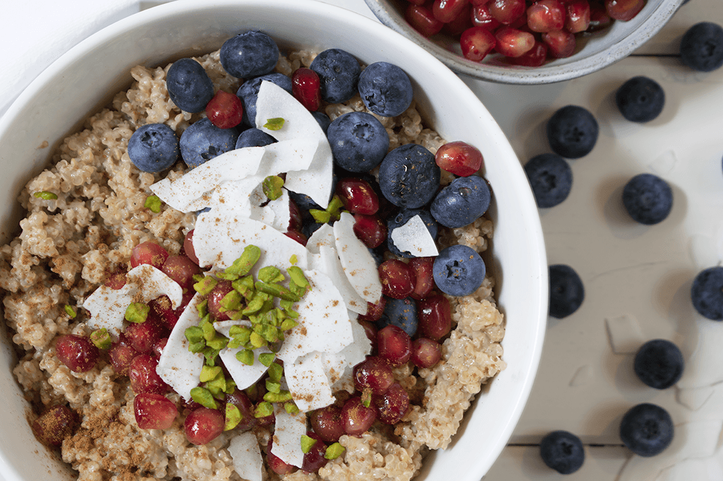 Quinoa-Porridge mit Blaubeeren, Granatapfel, Kokosflocken und Pistazien