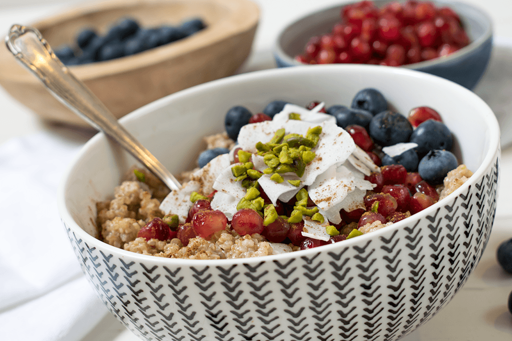 Quinoa-Porridge mit Blaubeeren, Granatapfel, Kokosflocken und Pistazien